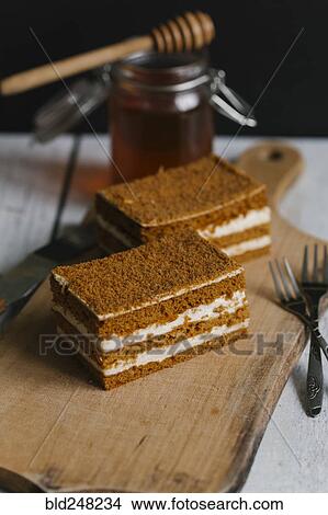 Slices of layer cake on cutting board with honey View Large Photo Image Picture - Slices of layer cake on cutting board with honey. Fotosearch