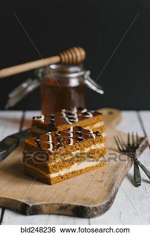 Slices of layer cake on cutting board with honey View Large Photo Image Stock Photograph - Slices of layer cake on cutting board with honey. Fotosearch