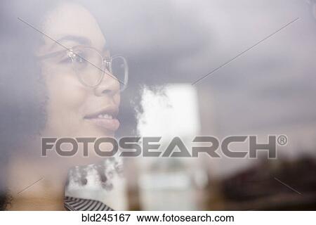 Stock Photo - Smiling African American woman behind window. Fotosearch