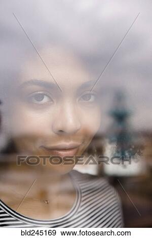 Stock Photo - Smiling African American woman behind window. Fotosearch