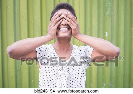 Picture - Smiling African American woman covering eyes. Fotosearch