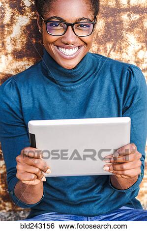 Smiling African American woman holding digital tablet View Large Photo Image Stock Photograph - Smiling African American woman holding digital tablet. Fotosearch