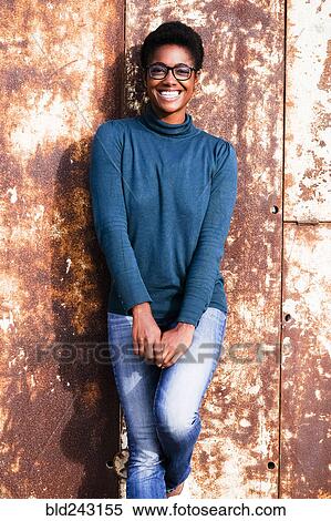 Smiling African American woman leaning on rusty metal wall View Large Photo Image Stock Photography - Smiling African American woman leaning on rusty metal wall. Fotosearch