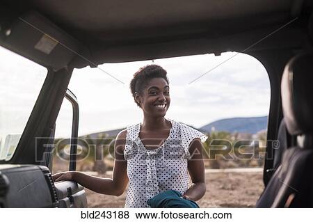 Smiling African American woman opening car door View Large Photo Image Stock Photo - Smiling African American woman opening car door. Fotosearch