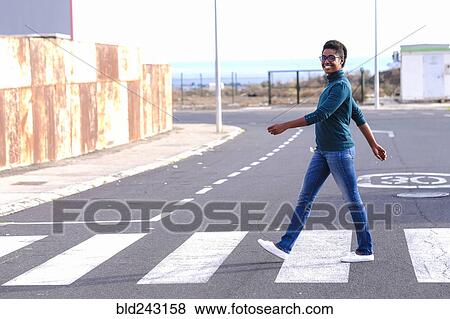 Smiling African American woman walking in crosswalk View Large Photo Image Stock Photo - Smiling African American woman walking in crosswalk. Fotosearch