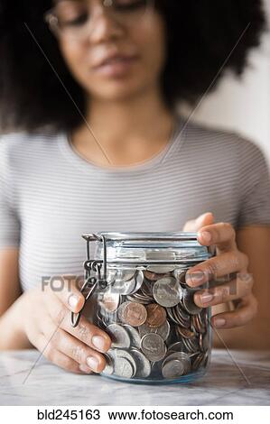 Smiling African American woman with jar full of coins View Large Photo Image Stock Image - Smiling African American woman with jar full of coins. Fotosearch