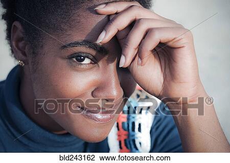 Stock Image - Smiling African American woman with hand on forehead. Fotosearch