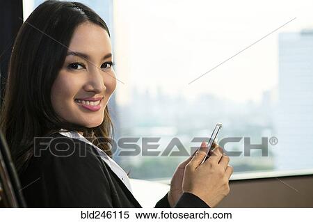 smiling Asian businesswoman texting on cell phone View Large Photo Image Stock Photography - smiling Asian businesswoman texting on cell phone. Fotosearch