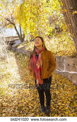 Smiling Asian woman smelling fresh air in autumn View Large Photo Image Stock Image - Smiling Asian woman smelling fresh air in autumn. Fotosearch