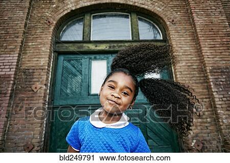 Stock Image - Smiling Black girl tossing hair. Fotosearch