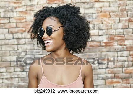 Smiling Black woman near brick wall View Large Photo Image Stock Image - Smiling Black woman near brick wall. Fotosearch