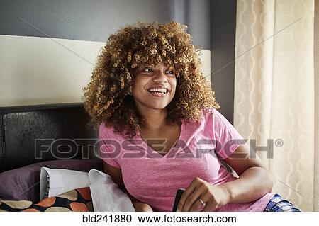 Smiling Black woman on bed looking away View Large Photo Image Stock Image - Smiling Black woman on bed looking away. Fotosearch