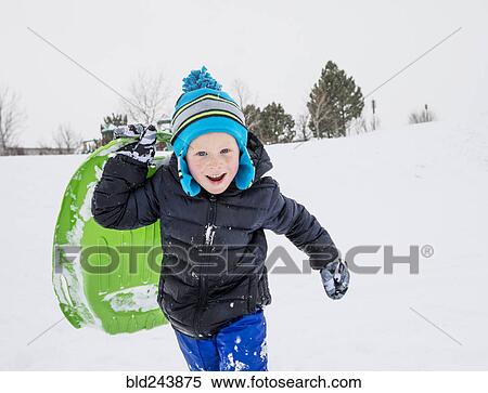 Smiling boy running with toboggan in winter View Large Photo Image Stock Photography - Smiling boy running with toboggan in winter. Fotosearch