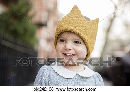 Stock Photo - Smiling Caucasian baby girl wearing crown hat. Fotosearch