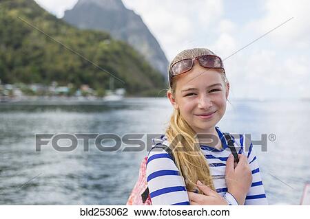 Stock Image - Smiling Caucasian girl near ocean. Fotosearch