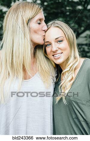 Smiling Caucasian mother kissing forehead of daughter View Large Photo Image Stock Photograph - Smiling Caucasian mother kissing forehead of daughter. Fotosearch