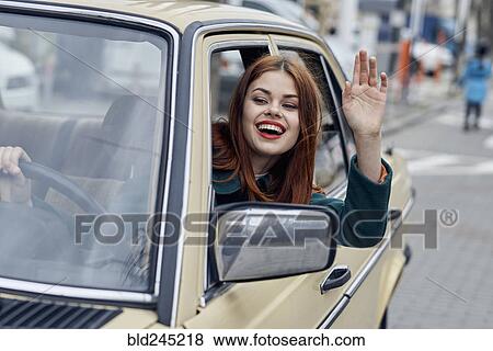 Smiling Caucasian woman driving car and waving View Large Photo Image Stock Photo - Smiling Caucasian woman driving car and waving. Fotosearch
