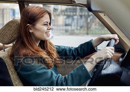 Stock Image - Smiling Caucasian woman driving car. Fotosearch