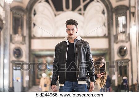 Smiling Caucasian woman gesturing behind man in lobby View Large Photo Image Stock Photograph - Smiling Caucasian woman gesturing behind man in lobby. Fotosearch