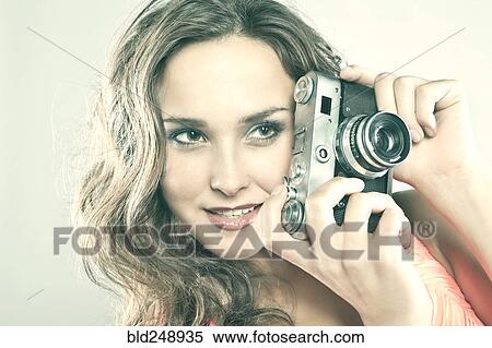Smiling Caucasian woman holding camera View Large Photo Image Stock Photography - Smiling Caucasian woman holding camera. Fotosearch