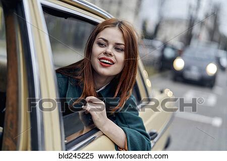 Stock Photography - Smiling Caucasian woman in back seat of car. Fotosearch