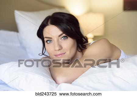 Smiling Caucasian woman laying on bed View Large Photo Image Stock Photography - Smiling Caucasian woman laying on bed. Fotosearch