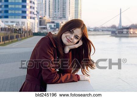 Smiling Caucasian woman leaning on wall at waterfront View Large Photo Image Stock Photograph - Smiling Caucasian woman leaning on wall at waterfront. Fotosearch