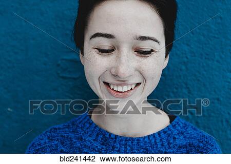 Smiling Caucasian woman near blue wall View Large Photo Image Stock Image - Smiling Caucasian woman near blue wall. Fotosearch