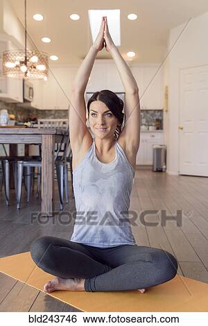 Stock Photograph - Smiling Caucasian woman performing yoga. Fotosearch