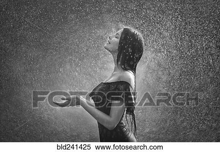 Stock Photography - Smiling Caucasian woman standing in rain. Fotosearch