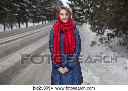 Picture - Smiling Caucasian woman standing near road in winter. Fotosearch
