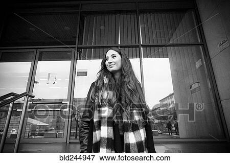 Smiling Caucasian woman standing near building View Large Photo Image Stock Photo - Smiling Caucasian woman standing near building. Fotosearch
