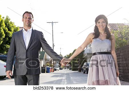 Stock Photo - Smiling couple holding hands in alley. Fotosearch