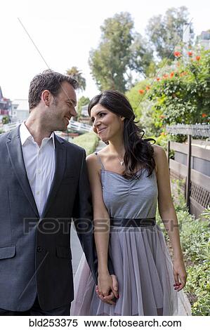 Stock Photography - Smiling couple holding hands outdoors. Fotosearch