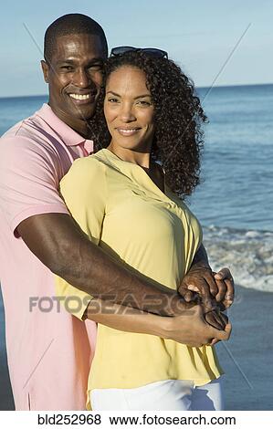 Smiling couple hugging on beach View Large Photo Image Stock Photo - Smiling couple hugging on beach. Fotosearch