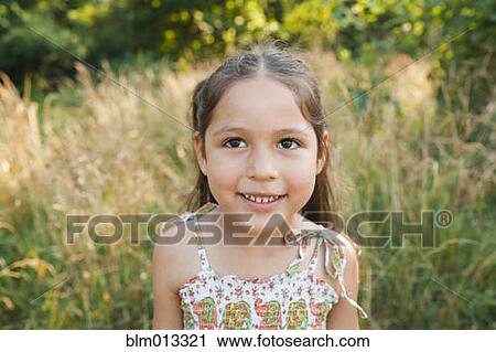 Stock Image - Smiling girl in field. Fotosearch