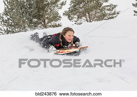 Smiling girl sliding on snowboard on hill in winter View Large Photo Image Stock Photograph - Smiling girl sliding on snowboard on hill in winter. Fotosearch