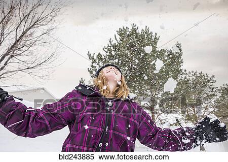 Stock Photography - Smiling girl throwing snow in air. Fotosearch