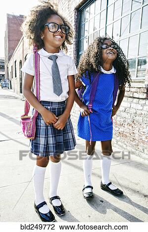 Smiling girls standing on sidewalk ready for school View Large Photo Image Stock Image - Smiling girls standing on sidewalk ready for school. Fotosearch
