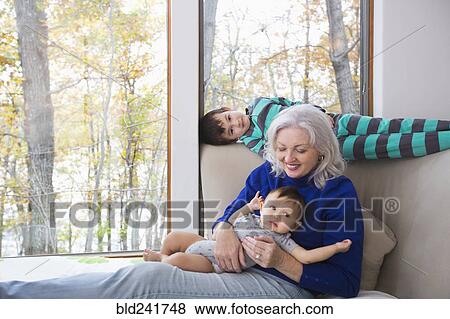 Smiling grandmother and grandsons near window View Large Photo Image Stock Photo - Smiling grandmother and grandsons near window. Fotosearch
