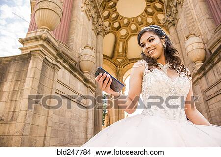 Smiling Hispanic girl texting on cell phone View Large Photo Image Picture - Smiling Hispanic girl texting on cell phone. Fotosearch