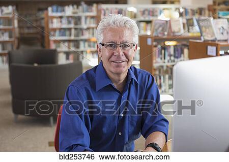 Smiling Hispanic man using computer in library View Large Photo Image Stock Photograph - Smiling Hispanic man using computer in library. Fotosearch