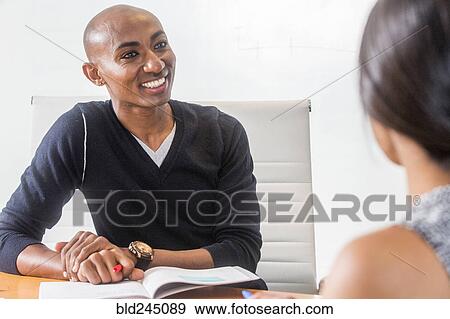 Smiling man listening in meeting View Large Photo Image Stock Photo - Smiling man listening in meeting. Fotosearch