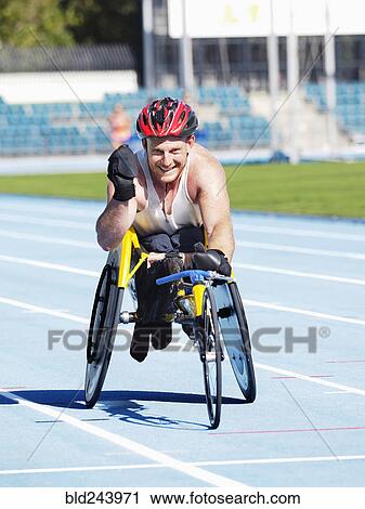 Smiling man racing in wheelchair on track View Large Photo Image Stock Image - Smiling man racing in wheelchair on track. Fotosearch
