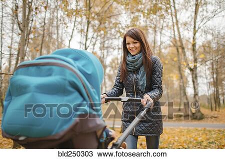 Smiling Middle Eastern woman pushing stroller in park View Large Photo Image Stock Image - Smiling Middle Eastern woman pushing stroller in park. Fotosearch