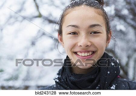 Stock Photo - Smiling Mixed Race girl covered in snow. Fotosearch
