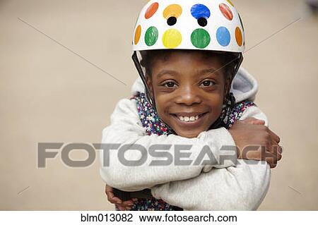 Stock Image - Smiling mixed race girl in helmet. Fotosearch