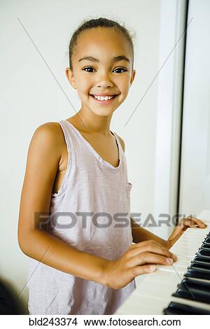 Smiling Mixed Race girl playing music on keyboard View Large Photo Image Picture - Smiling Mixed Race girl playing music on keyboard. Fotosearch