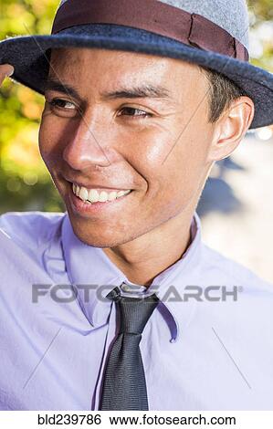 Stock Photograph - Smiling Mixed Race man wearing fedora. Fotosearch
