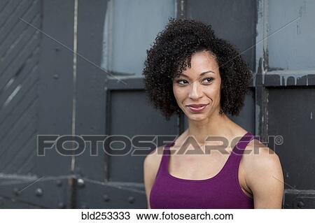 Smiling Mixed Race woman leaning on door View Large Photo Image Stock Image - Smiling Mixed Race woman leaning on door. Fotosearch